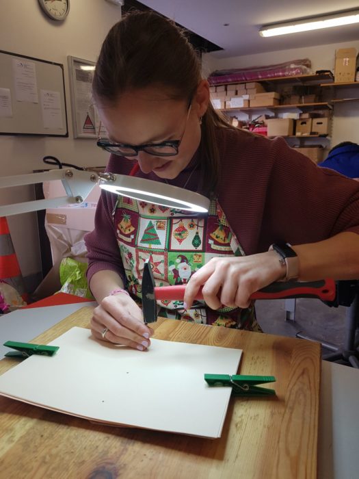 Sophie concentrée sur la mise en place de billes pour le braille