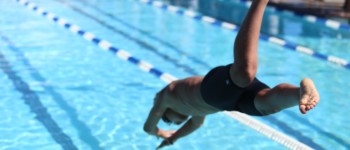 personne en train de plonger dans une piscine de type piscine municipale