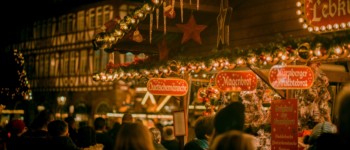 Photo d'une foule devant un stand de pains d'épices et vin chaud sur un marché de Noël