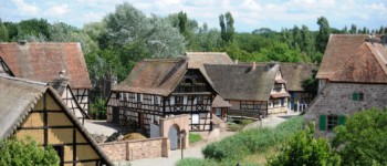 photo de l'écomusée d'alsace avec 4 maisons à colombage entourées d'arbres