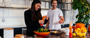 Deux personnes dans une cuisine préparent une salade