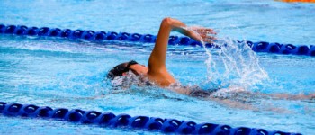 personne qui nage en crawl dans une piscine