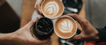 Mains tenant des tasses de café trinquent ensemble (vue de haut)